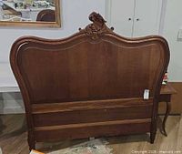 Full view of walnut headboard with carved crest