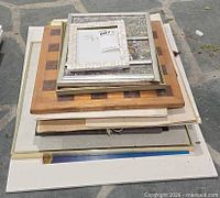 Stack showing chess board, multiple framed items