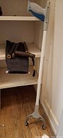 Foldable cane and Unger reacher leaning against shelving