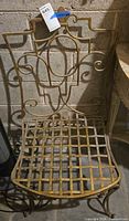 Front view of wrought iron chair showing lattice seat and scroll back