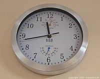 Front view of the Hito wall clock showing dial, frame and gauges