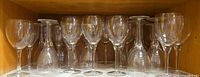 Row of wine glasses inside cabinet showing quantity and style