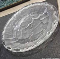 Top angle of frosted crystal Lalique Chene plate showing oak leaf motif and scalloped rim