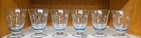 Six Lenox Heather blue footed tumblers lined up on shelf