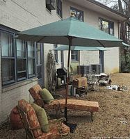 Umbrella and base beside lounge chairs