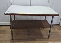 Front view showing white laminate top, wood shelf, chrome legs