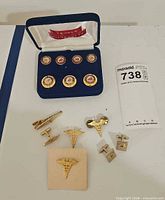Lot overview showing Temple University button set, caduceus accessories and cufflinks