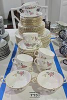 Front view showing two-handled soup bowls, teacups and stacked plates