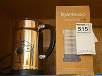 Frother next to original box showing brand and model