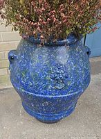 Front view of mottled blue ceramic planter with dried plant