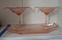 Pair of pink Heisey Flamingo Empress compotes on stems with Twist relish tray