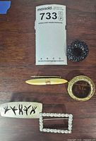 Overall lot showing five brooches laid out