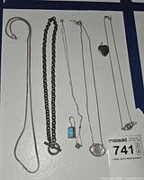 Group shot of all necklaces and single earring laid out on board