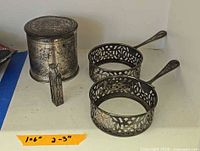 Cup holders and lidded container showing overall design and tarnish