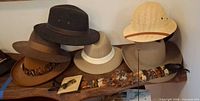 Row of felt hats, feather band and accessories on shelf