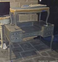 Front view of grey French Provincial vanity with bench placed on top