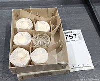 Box holding six glass dappen dishes with cardboard dividers, five wrapped, one unwrapped