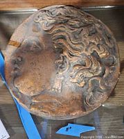Front view of plaster medallion showing profile relief and wear