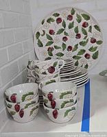 Full view of dish set on shelf showing bowls, cups, plates and serving platter