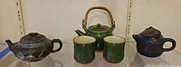 Group shot of three teapots and two cups