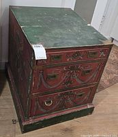 Front and left side view of three-drawer hand-painted table showing brass pulls and corner accents
