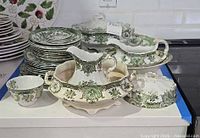 Overview of stacked plates, cups, covered pieces and gravy boat
