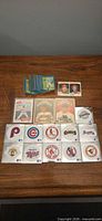 Overall lot layout: stack of Super Bowl trivia cards, two small photo stickers, four sleeved baseball cards, two rows of Fleer logo stickers