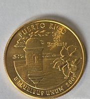 Reverse side of gold-plated 2009 Puerto Rico quarter showing garita, sea and hibiscus