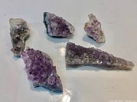 Group shot of five amethyst clusters on white surface