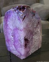 Front view of amethyst geode showing pink-purple crystals and polished base