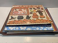 stack of patterned Halloween pumpkin sheets on top of assorted papers