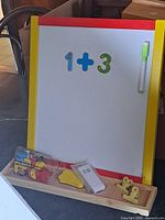 Front view of board showing frame colours, magnetic numbers, marker, tray with accessories