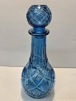 Full view of cobalt blue pressed glass decanter with stopper showing diamond quilted pattern