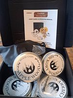 Open kit showing smoker, four wood chip tins, filters and manual