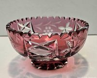 Oblique view of cranberry cut-to-clear bowl showing exterior cuts and foot