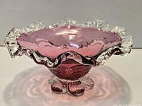 Side view showing cranberry bowl, clear ruffled rim, and clear petal foot