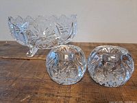 Footed crystal dish and two round candle holders displayed together