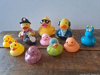 Group shot of all eleven vinyl bath toys on wooden surface