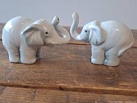 Front view of both ceramic elephant shakers facing each other