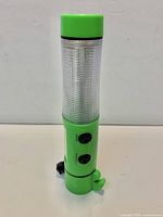 Full view of green emergency LED beacon flashlight standing upright