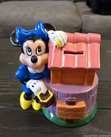 Full view of Minnie Mouse plastic coin bank showing figure, well, coin slot, colours and overall condition