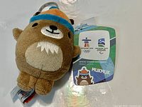 Front view of Mukmuk plush keychain with hang tag visible