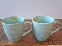 Front view of both mint green Pfaltzgraff mugs