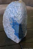 Front view of polished blue and white agate geode freeform, showing crystalline interior and banding