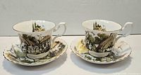 Two teacups and two saucers showing pattern and condition