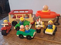 Group shot of Fisher-Price Mini-Bus, motorbike, two green cars, yellow racer, boat, figures and dog