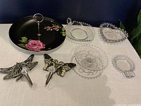 Group shot of cake stand, three clear glass dishes and two enamel insect hooks