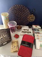 Overview of lot showing napkins, bead garlands, ornaments, CDs, metal candle holder and carrier