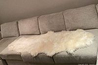 Sheepskin runner draped on sofa showing overall size and color