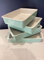 Stack of four seafoam Martha Stewart stoneware baking dishes showing size variation and color